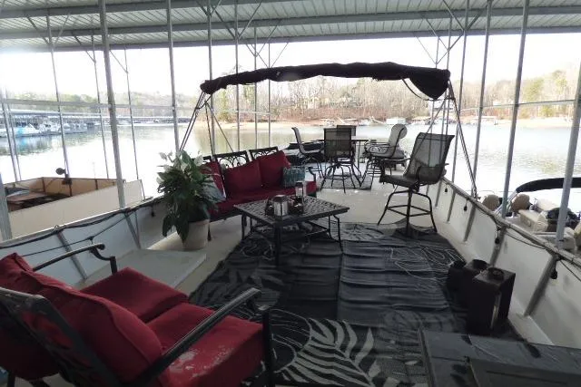 Slide: The Image of 1978 Lazy Days 14x57 houseboat with cozy outdoor seating and scenic lake view. - 10