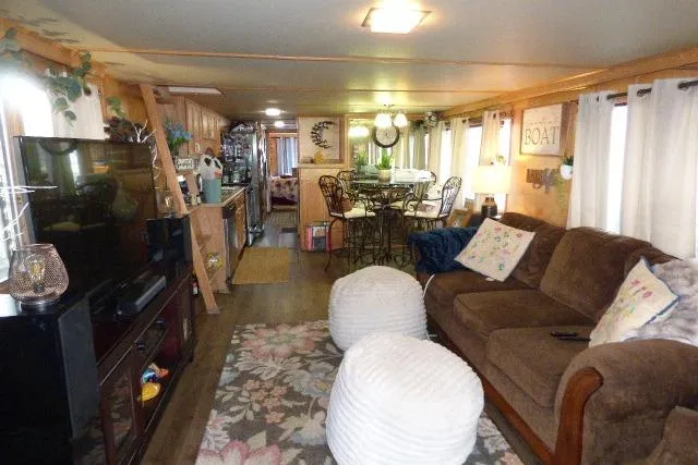 Slide: The Image of Interior of a 1978 Lazy Days 14x57 houseboat with cozy living area and dining space. - 2