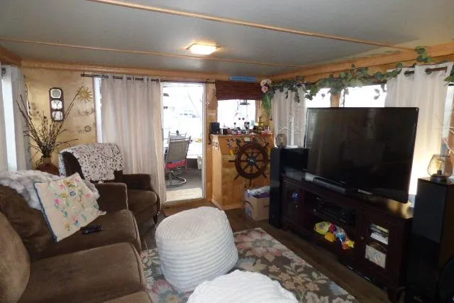 Slide: The Image of Cozy 1978 Lazy Days 14x57 houseboat interior with TV, seating, and nautical decor. - 3