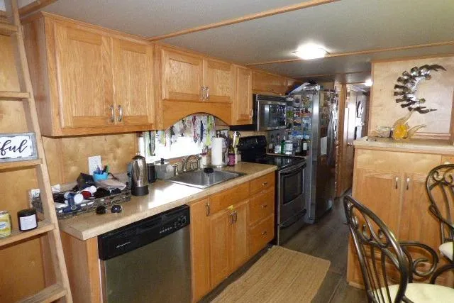 Slide: The Image of 1978 Lazy Days 14x57 houseboat kitchen with wooden cabinets and modern appliances. - 4