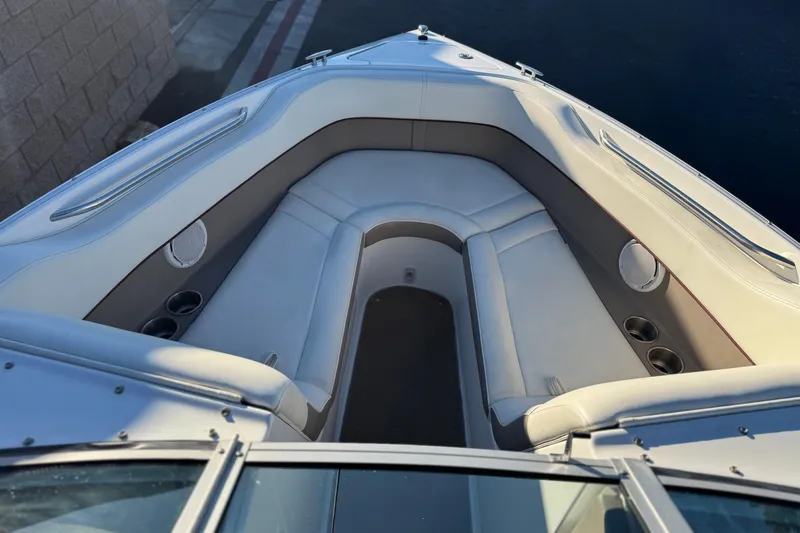 Slide: The Image of 2006 Cobalt 220 boat interior with white seating and cup holders. - 14