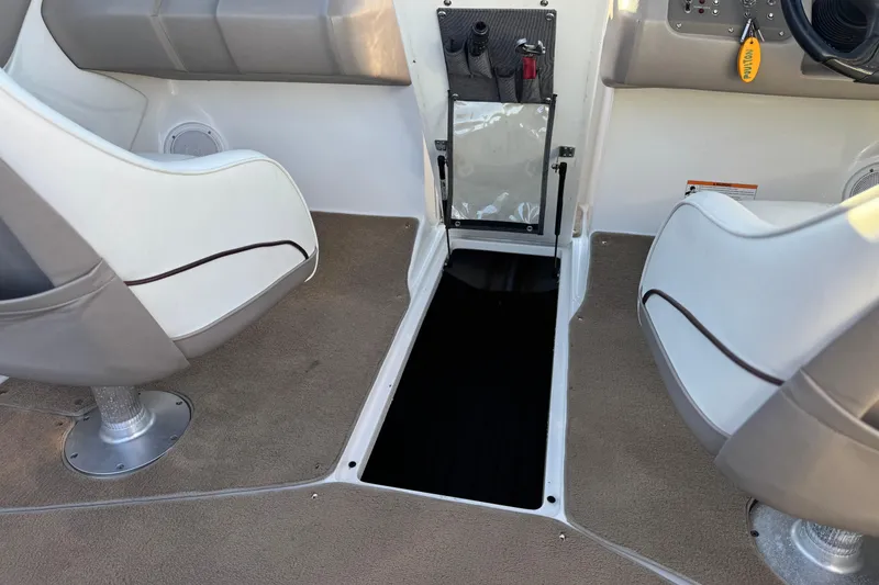 Slide: The Image of Interior of a 2006 Cobalt 220 boat, featuring seating and storage compartment. - 26