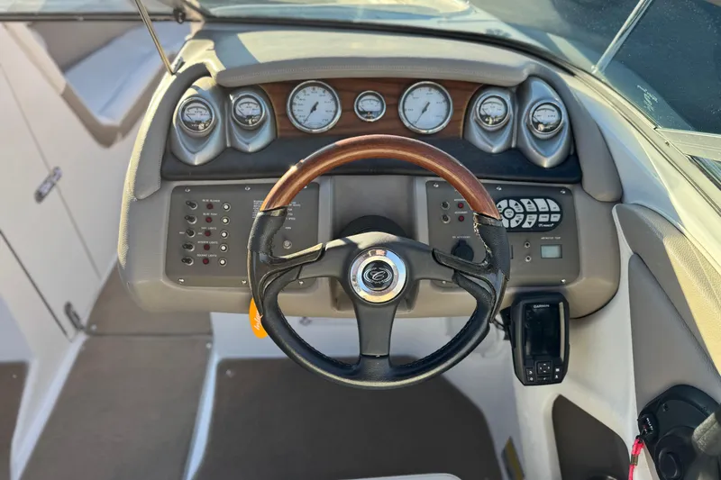 Slide: The Image of Steering wheel and dashboard of a 2006 Cobalt 220 boat with gauges and controls. - 28