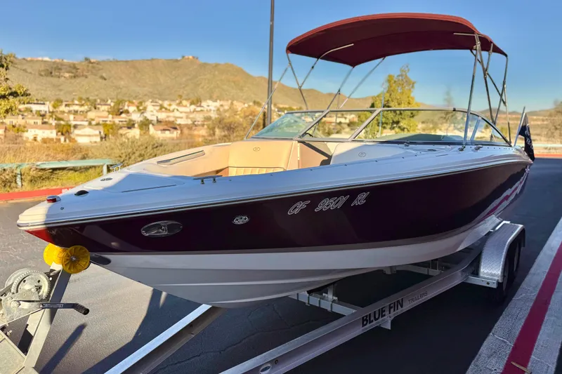 Slide: The Image of 2006 Cobalt 220 boat on trailer with red canopy, scenic background. - 3