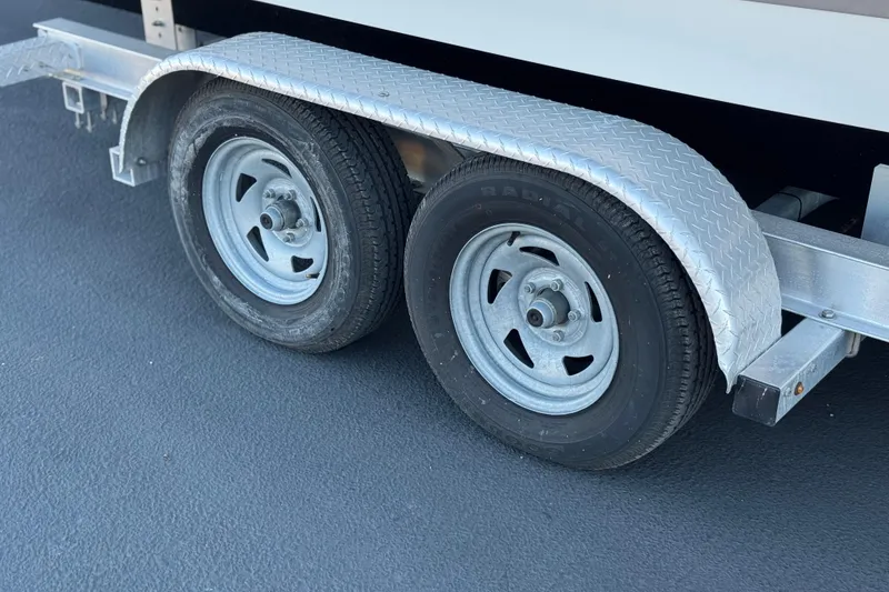 Slide: The Image of Trailer wheels with metal fender on a 2006 Cobalt 220 boat trailer. - 31
