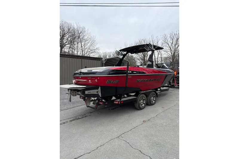 Slide: The Image of 2016 Malibu Wakesetter 25 LSV boat on trailer, red and black design. - 5