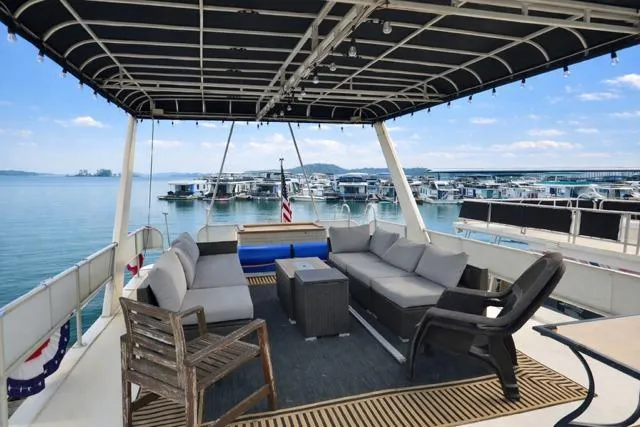 Slide: The Image of 1987 Sumerset 14x64 houseboat with spacious deck seating and scenic marina view. - 10