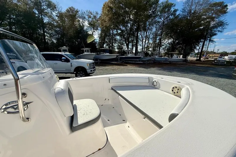 Slide: The Image of 2020 Tidewater 180 CC Adventure boat interior with seating and console, parked outdoors. - 18