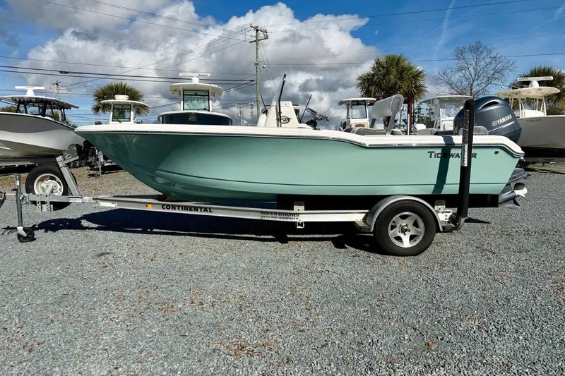 Slide: The Image of 2020 Tidewater 180 CC Adventure boat on trailer, parked outdoors under cloudy sky. - 7