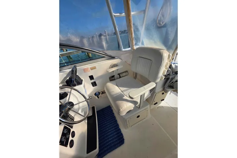 Slide: The Image of 2001 Boston Whaler 275 Conquest helm with steering wheel and captain's chair. - 10