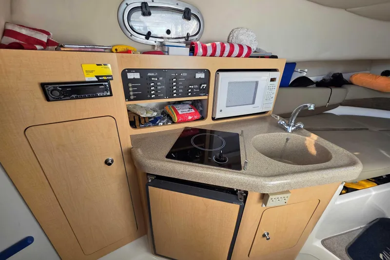 Slide: The Image of 2001 Boston Whaler 275 Conquest cabin with kitchenette, microwave, and sink. - 14