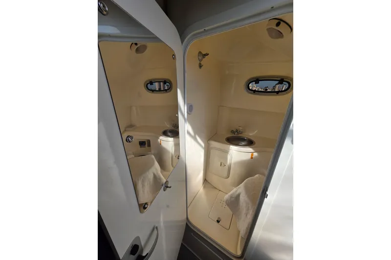 Slide: The Image of Interior of 2001 Boston Whaler 275 Conquest boat bathroom with sink and porthole. - 16