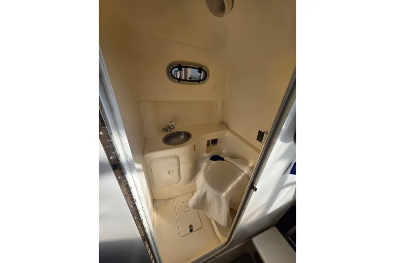Slide: The Image of Interior of 2001 Boston Whaler 275 Conquest boat bathroom with sink and porthole. - 17