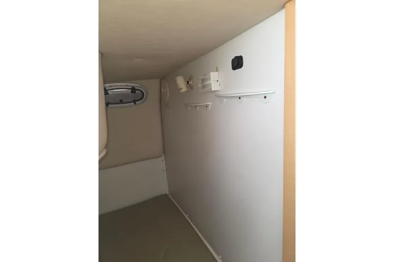 Slide: The Image of Interior cabin of 2001 Boston Whaler 275 Conquest boat, featuring a small window and wall fixtures. - 18
