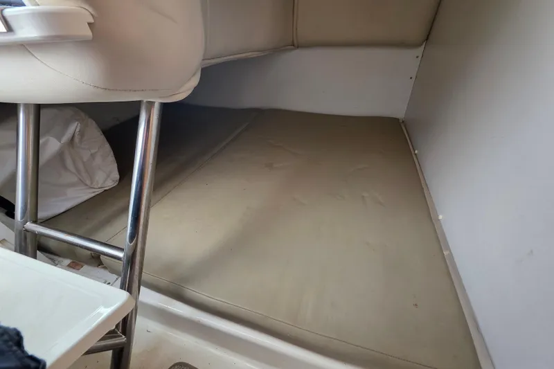 Slide: The Image of Interior cabin of 2001 Boston Whaler 275 Conquest boat, featuring a cushioned sleeping area. - 19