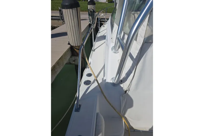 Slide: The Image of 2001 Boston Whaler 275 Conquest docked, showing side rail and deck details. - 20