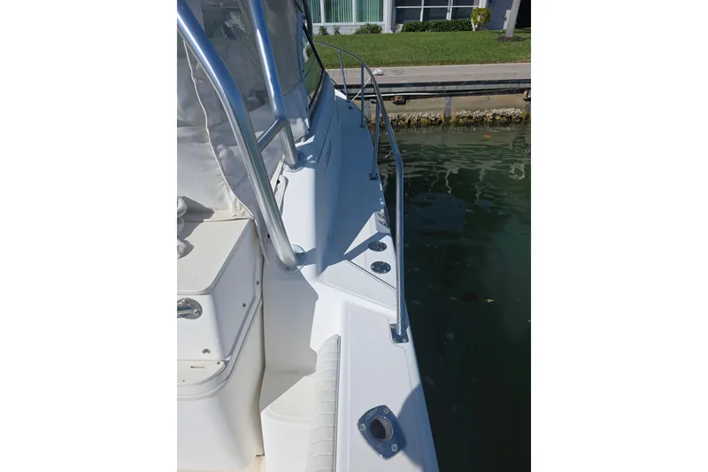 Slide: The Image of 2001 Boston Whaler 275 Conquest boat docked, showcasing side deck and railing. - 21