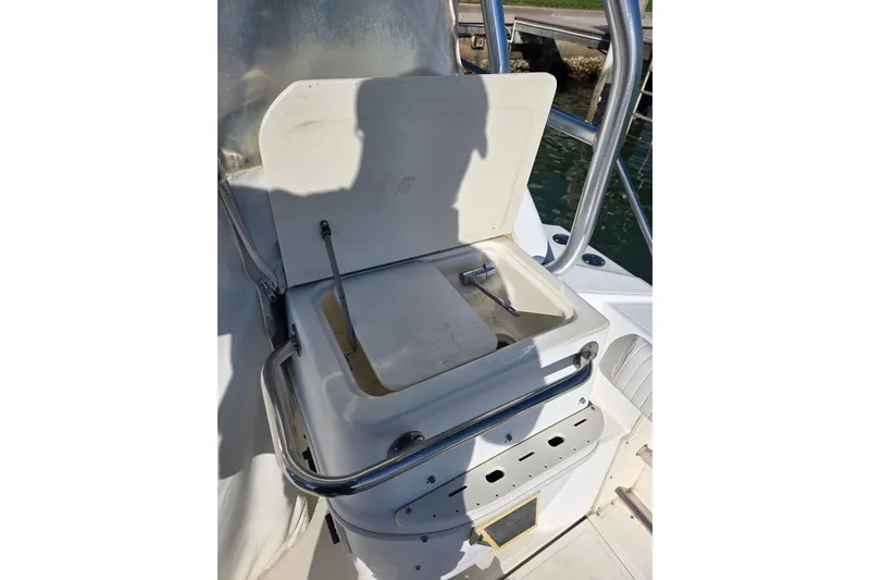 Slide: The Image of Boston Whaler 275 Conquest 2001 boat storage compartment with open lid and metal railing. - 23