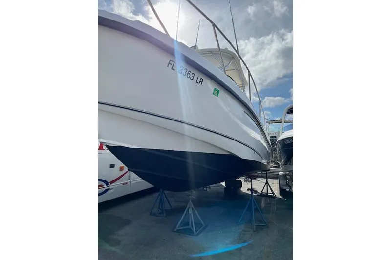Slide: The Image of 2001 Boston Whaler 275 Conquest docked at a marina with clear water. - 3