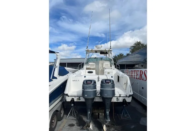 Slide: The Image of 2001 Boston Whaler 275 Conquest boat with covered cockpit and fishing rod holders. - 6