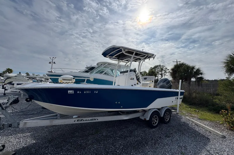 Slide: The Image of 2019 Wellcraft 221 Bay boat on trailer under cloudy sky. - 1