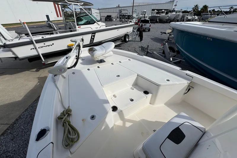 Slide: The Image of 2019 Wellcraft 221 Bay boat on display at a marina, featuring a spacious deck. - 13