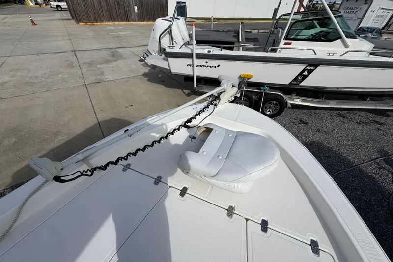 Slide: The Image of 2019 Wellcraft 221 Bay boat with trolling motor and trailer in a marina setting. - 15