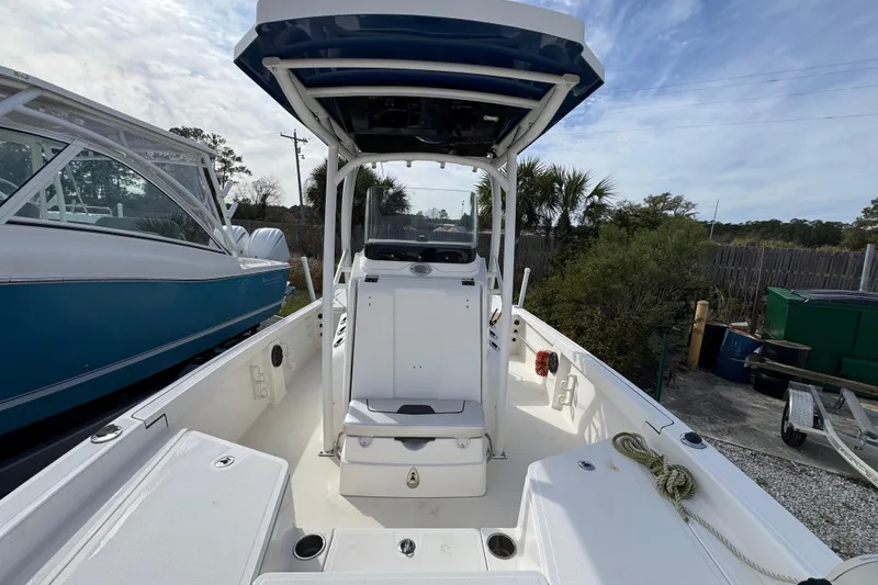 Slide: The Image of 2019 Wellcraft 221 Bay boat interior with center console and seating, docked outdoors. - 19