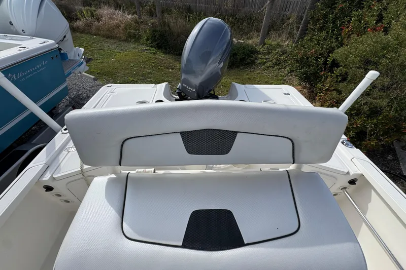 Slide: The Image of 2019 Wellcraft 221 Bay boat with cushioned seating and outboard motor. - 27