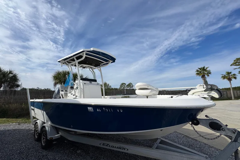 Slide: The Image of 2019 Wellcraft 221 Bay boat on trailer under a clear blue sky. - 6
