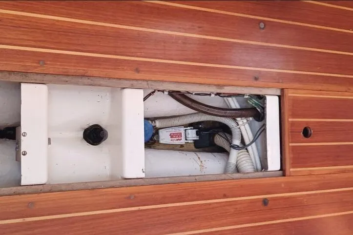 Slide: The Image of 1988 Tartan 28 sailboat interior with open wooden floor panel revealing wiring and components. - 36