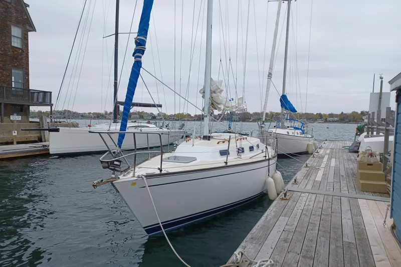 Slide: The Image of 1988 Tartan 28 sailboat docked at a marina with other boats. - 6