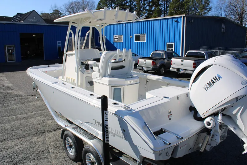 Slide: The Image of 2026 Pathfinder 2400 Open boat with Yamaha engine on trailer, parked outside blue building. - 8