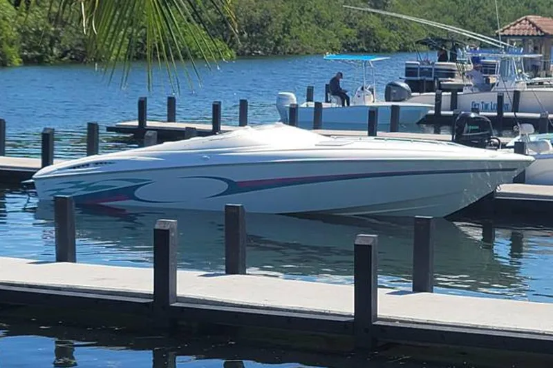 The Image of 1999 Baja 29 Outlaw boat parked on trailer. - 0