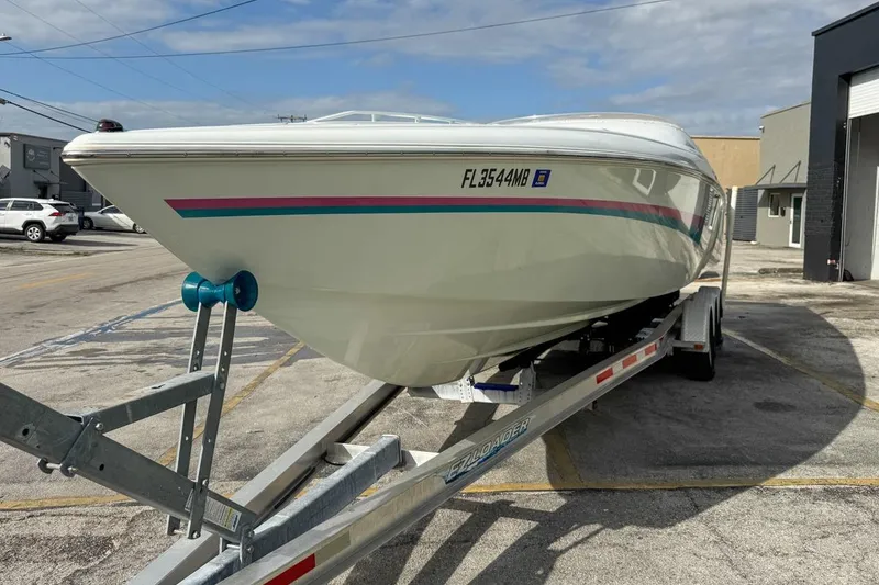 Slide: The Image of 1999 Baja 29 Outlaw boat on trailer in parking lot, side view. - 10