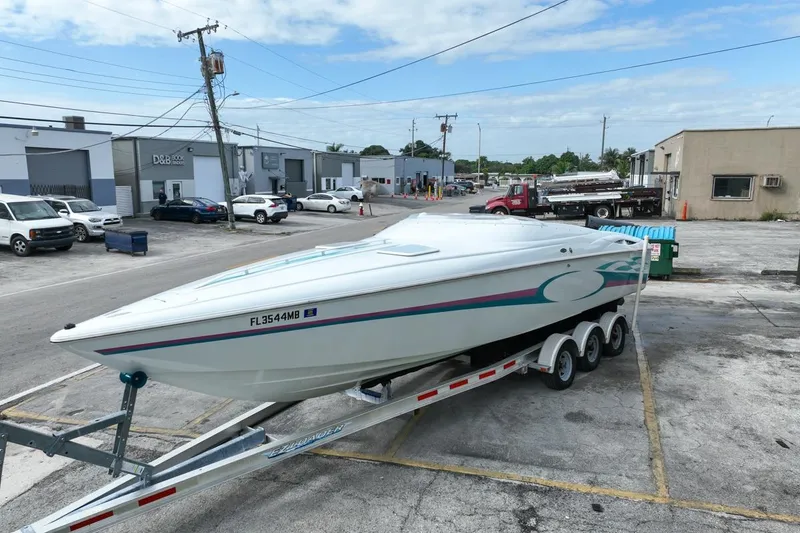 Slide: The Image of 1999 Baja 29 Outlaw speedboat on trailer in industrial area parking lot. - 11