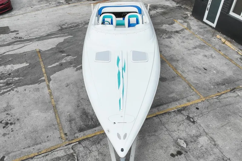 Slide: The Image of Aerial view of a 1999 Baja 29 Outlaw boat on a parking lot. - 13