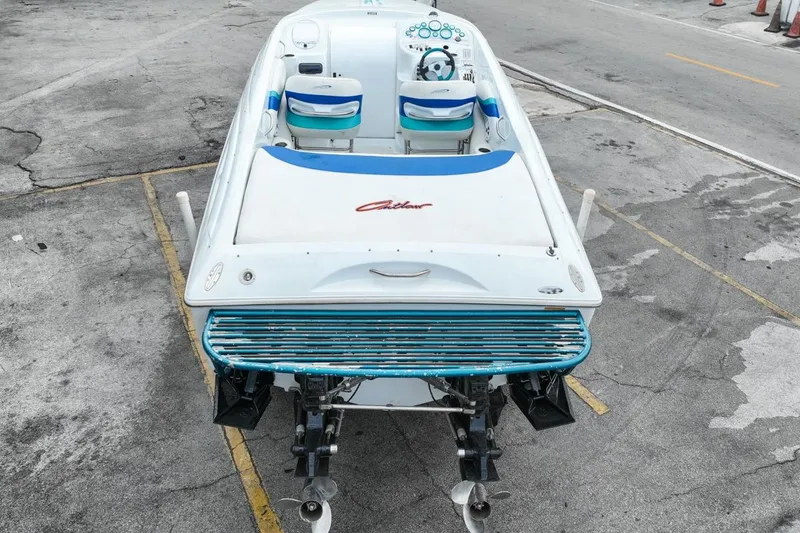 Slide: The Image of 1999 Baja 29 Outlaw speedboat with dual engines, parked on concrete surface. - 14