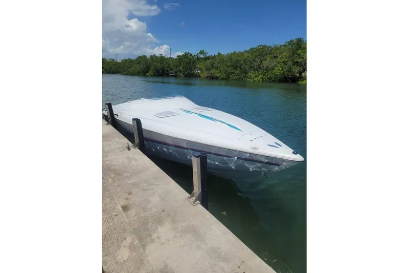 Slide: The Image of 1999 Baja 29 Outlaw speedboat on trailer in parking lot. - 2