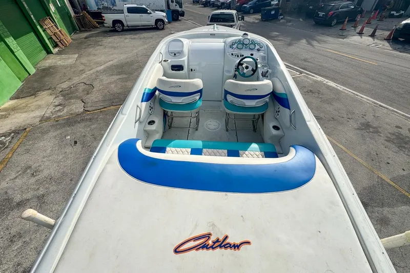 Slide: The Image of 1999 Baja 29 Outlaw boat interior with blue and white seating, parked on street. - 20