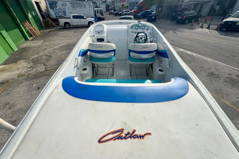 Slide: The Image of 1999 Baja 29 Outlaw speedboat with blue and white interior, parked in an urban setting. - 21
