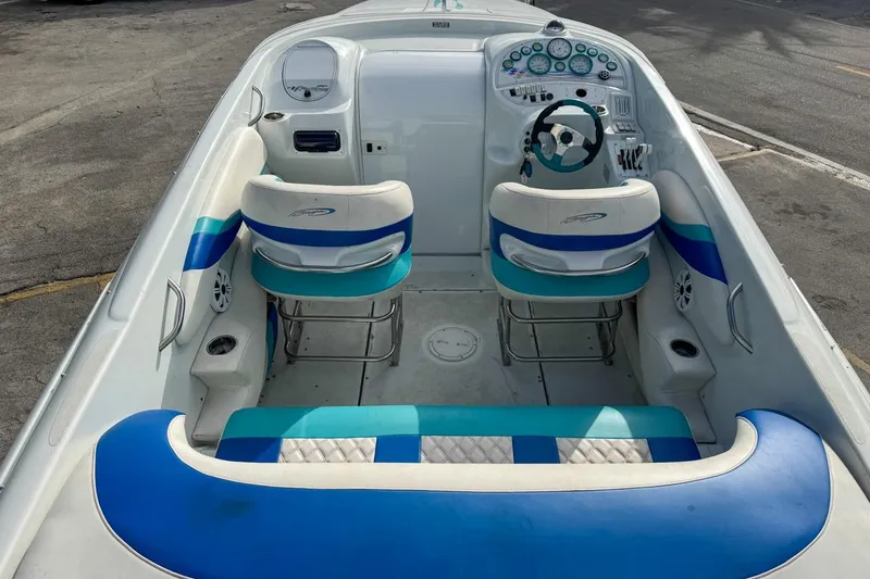 Slide: The Image of 1999 Baja 29 Outlaw boat interior with blue and white seating and dashboard. - 24