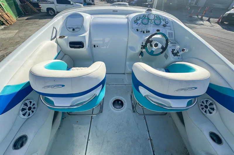Slide: The Image of 1999 Baja 29 Outlaw boat cockpit with white and blue seating, steering wheel, and dashboard. - 30