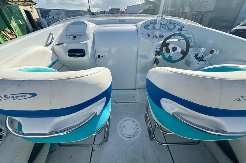 Slide: The Image of 1999 Baja 29 Outlaw boat cockpit with white and blue seating, steering wheel, and dashboard controls. - 32