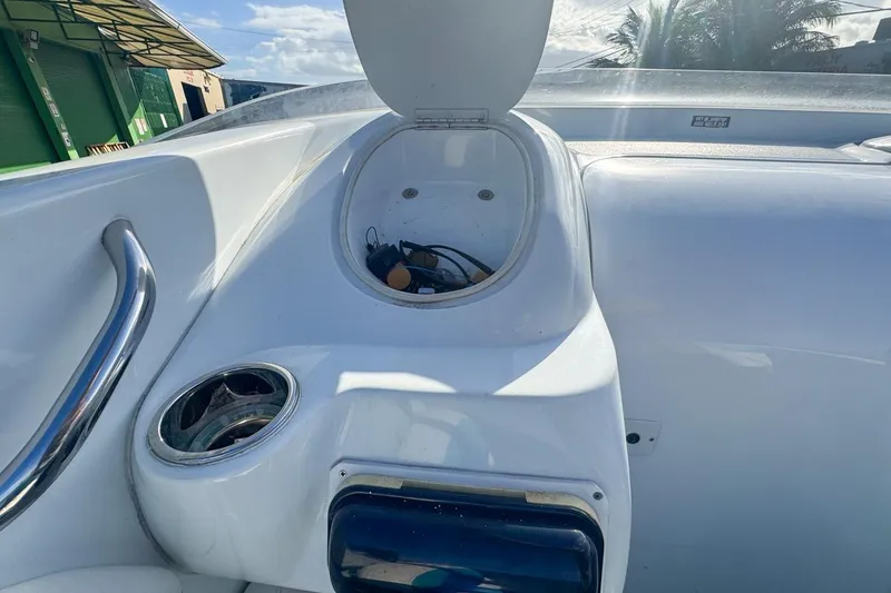 Slide: The Image of 1999 Baja 29 Outlaw boat interior with open storage compartment and cup holder. - 35