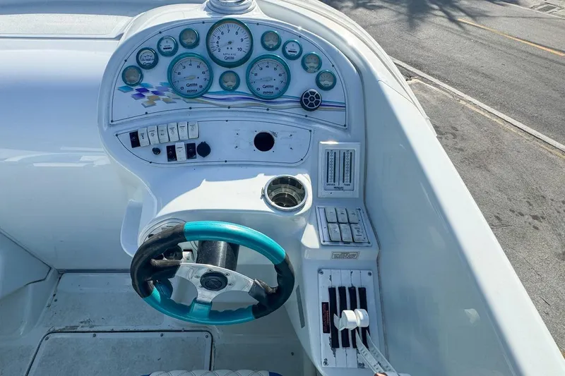 Slide: The Image of 1999 Baja 29 Outlaw boat dashboard with gauges and steering wheel. - 37