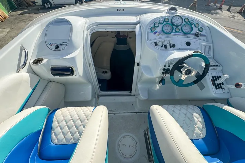 Slide: The Image of 1999 Baja 29 Outlaw boat interior with blue and white seating and dashboard controls. - 44