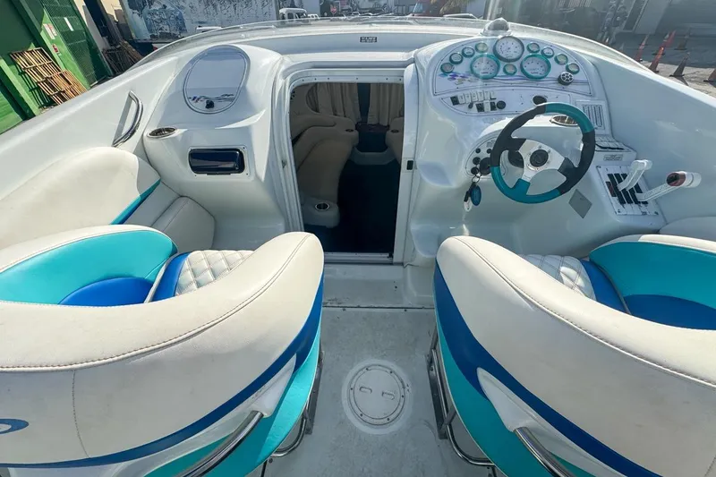 Slide: The Image of 1999 Baja 29 Outlaw boat interior with blue and white seating and control panel. - 45