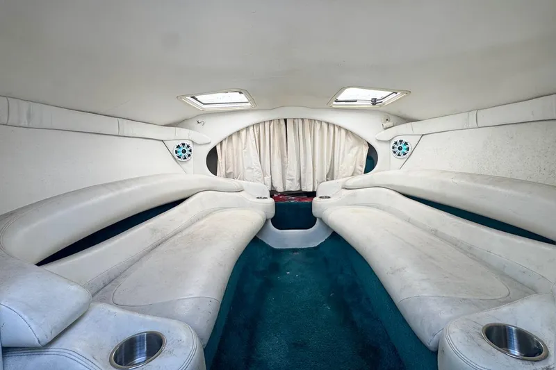 Slide: The Image of Interior of a 1999 Baja 29 Outlaw boat with white seating and teal carpet. - 49