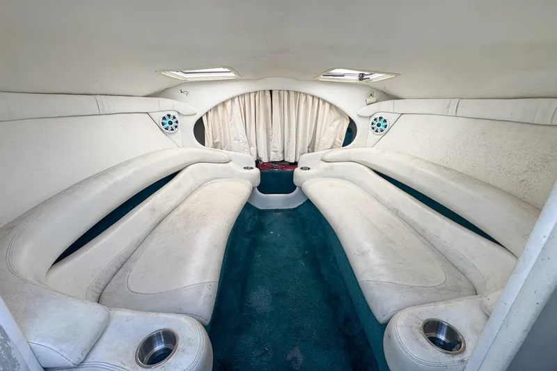 Slide: The Image of Interior of a 1999 Baja 29 Outlaw boat with white seating and teal carpet. - 50
